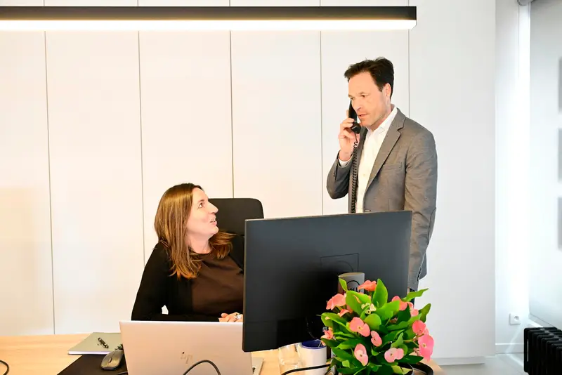 Man belt terwijl een collega werkt in een modern kantoor